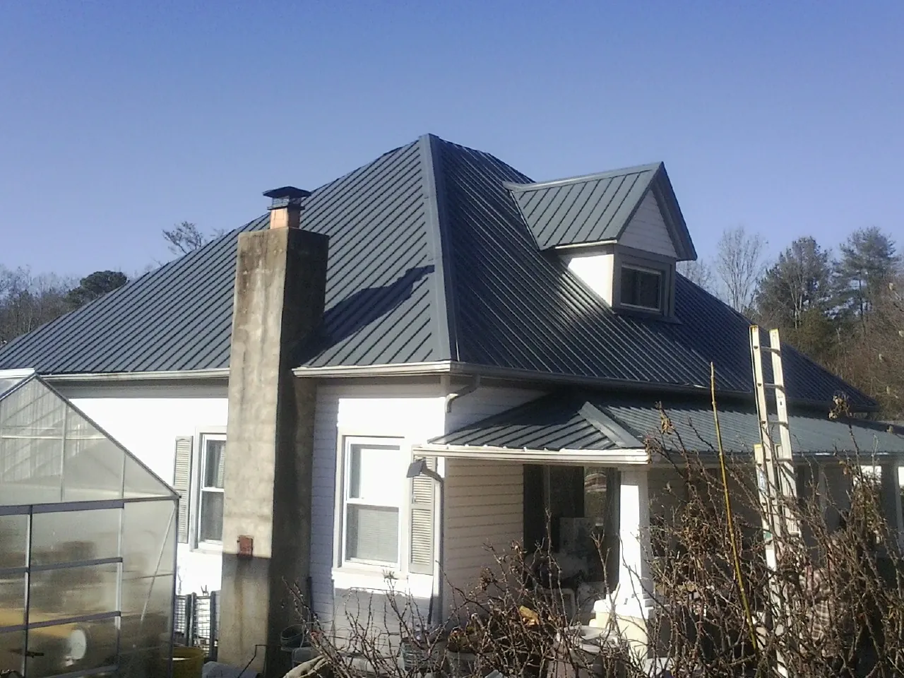 Dark blue standing seam metal roof on a white farmhouse with dormer — Slate & Tile Roof Repair by Roofing Brothers in Cape Elizabeth