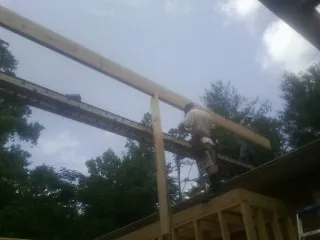 Carpenter setting a ridge beam over a new addition frame — Ice Dam Removal by Roofing Brothers in Cape Elizabeth